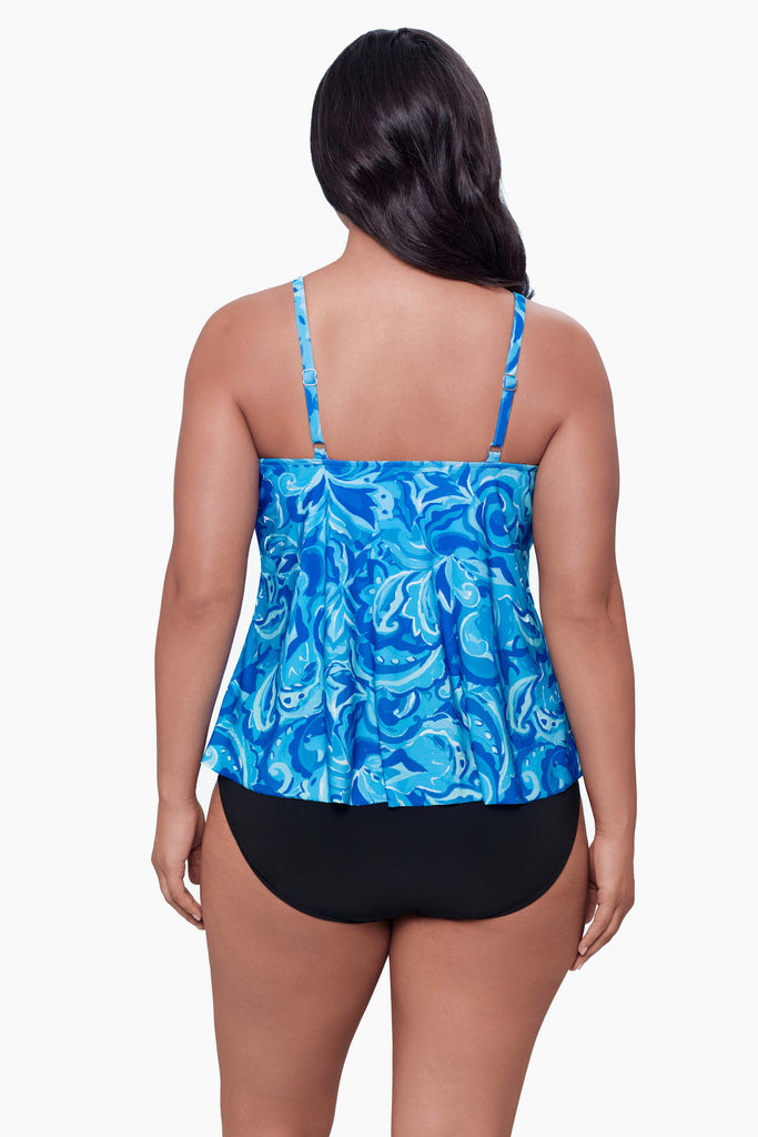 Woman turned away wearing a tiered tankini top with an abstract blue print