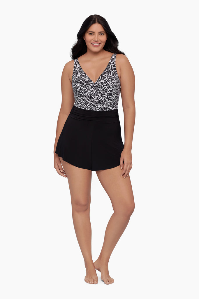 Woman wearing a swim romper with a black and white print