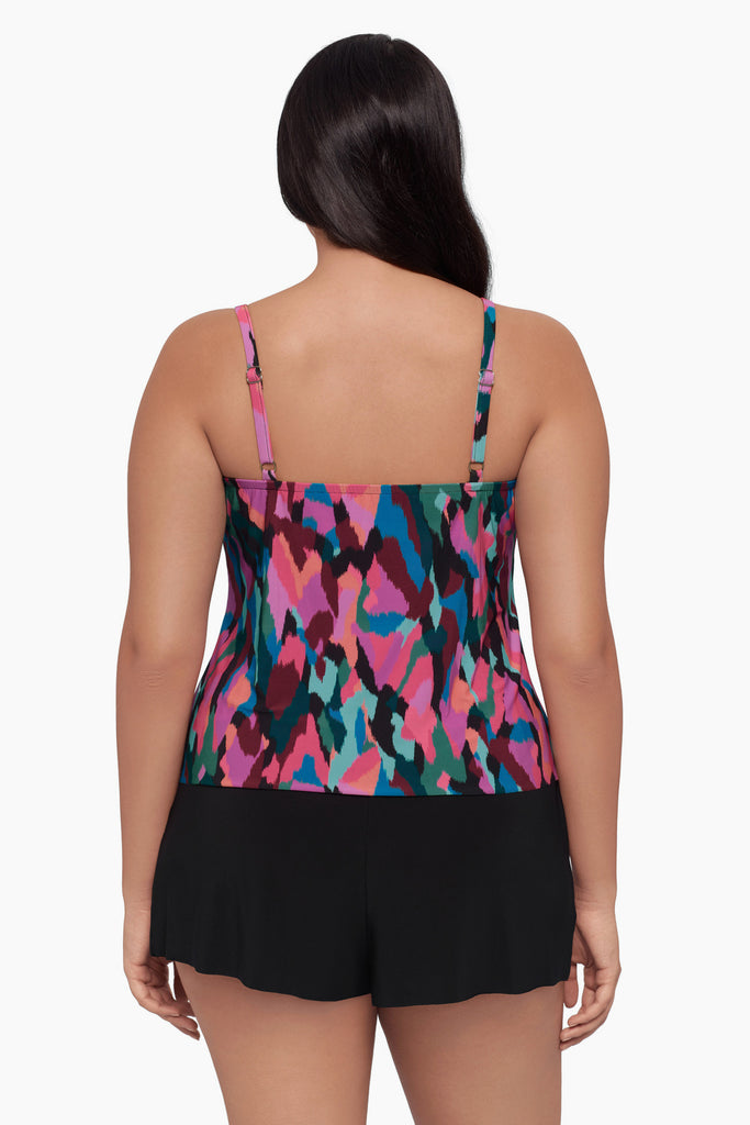 Woman turned away wearing a swim romper with a collage patchwork print