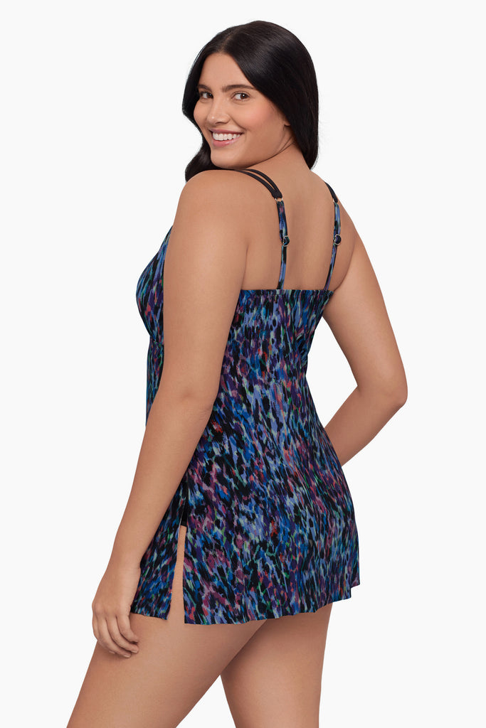 Woman turned left wearing a swim dress with a blue abstract pattern