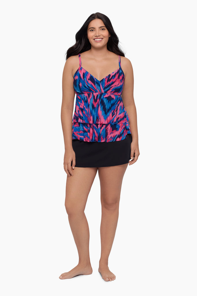 Woman wearing a tankini top with a pink and blue pattern