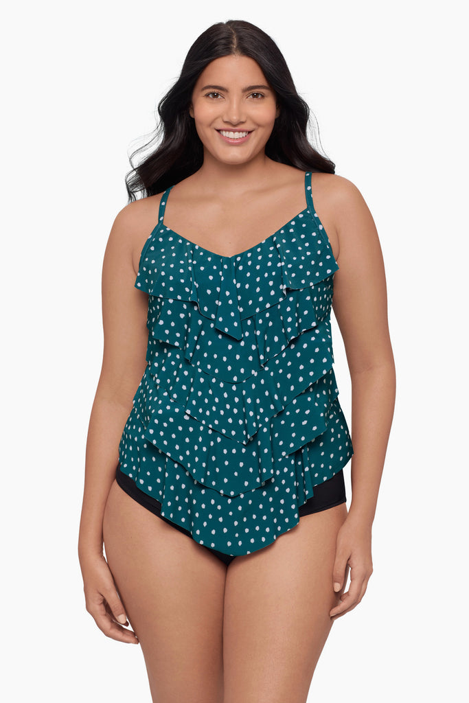 Woman wearing a tiered tankini top with a white polka dot pattern