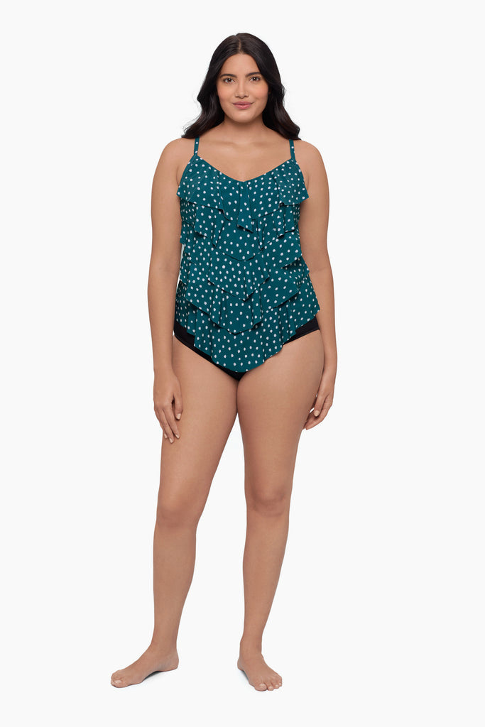 Woman wearing a tiered tankini top with a white polka dot pattern