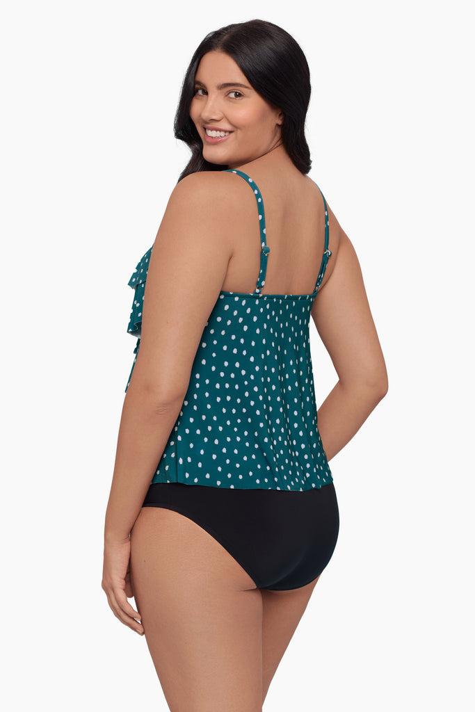 Woman turned left wearing a tiered tankini top with a white polka dot pattern