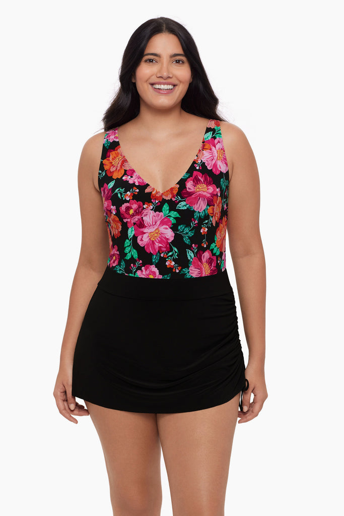 Woman wearing a swim dress with a floral pattern on the bust