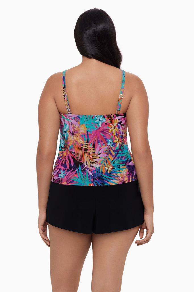 Woman turned away wearing a swim romper with a neon palm leaf print 