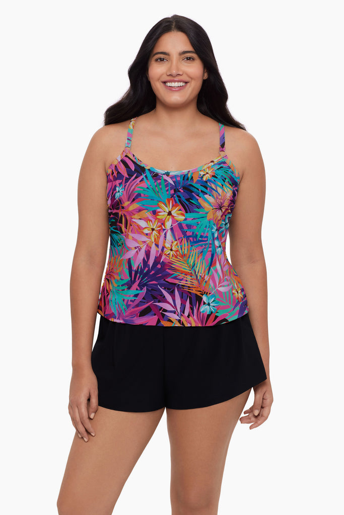 Woman wearing a swim romper with a neon palm leaf print 