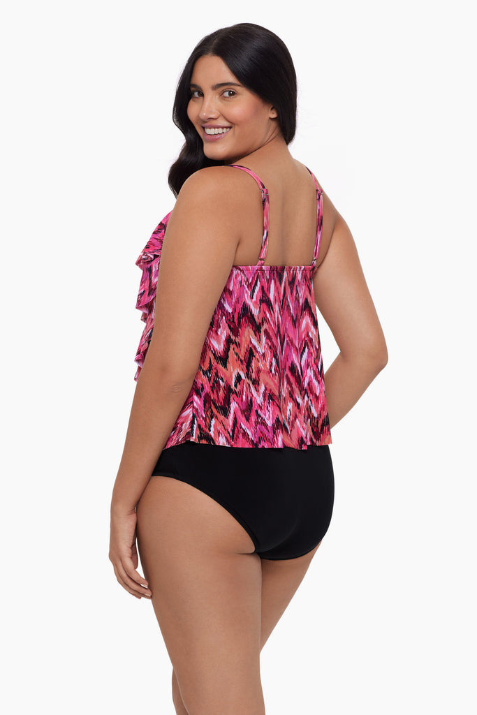 Woman turned left wearing a tiered tankini top with an abstract pink pattern
