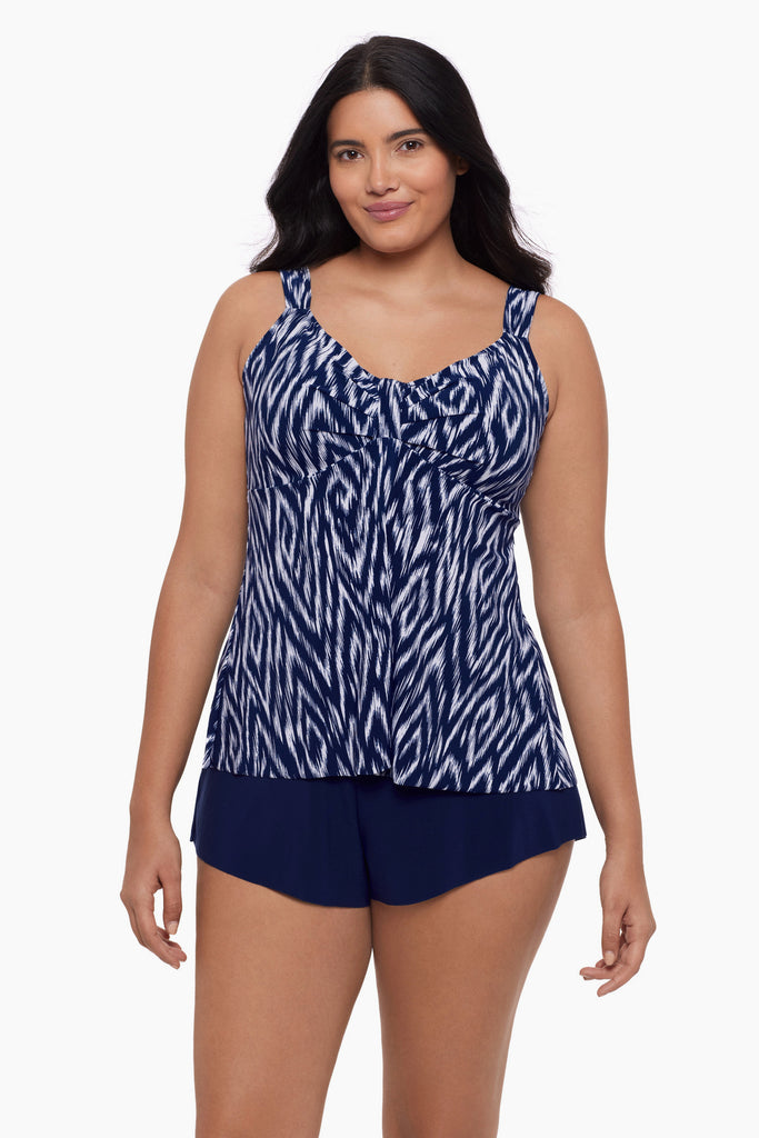 Woman wearing a tankini top with an abstract blue and white print