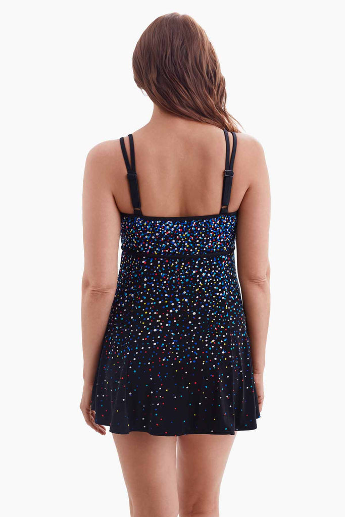 Woman turned away wearing a swim dress with a multicolored dot pattern
