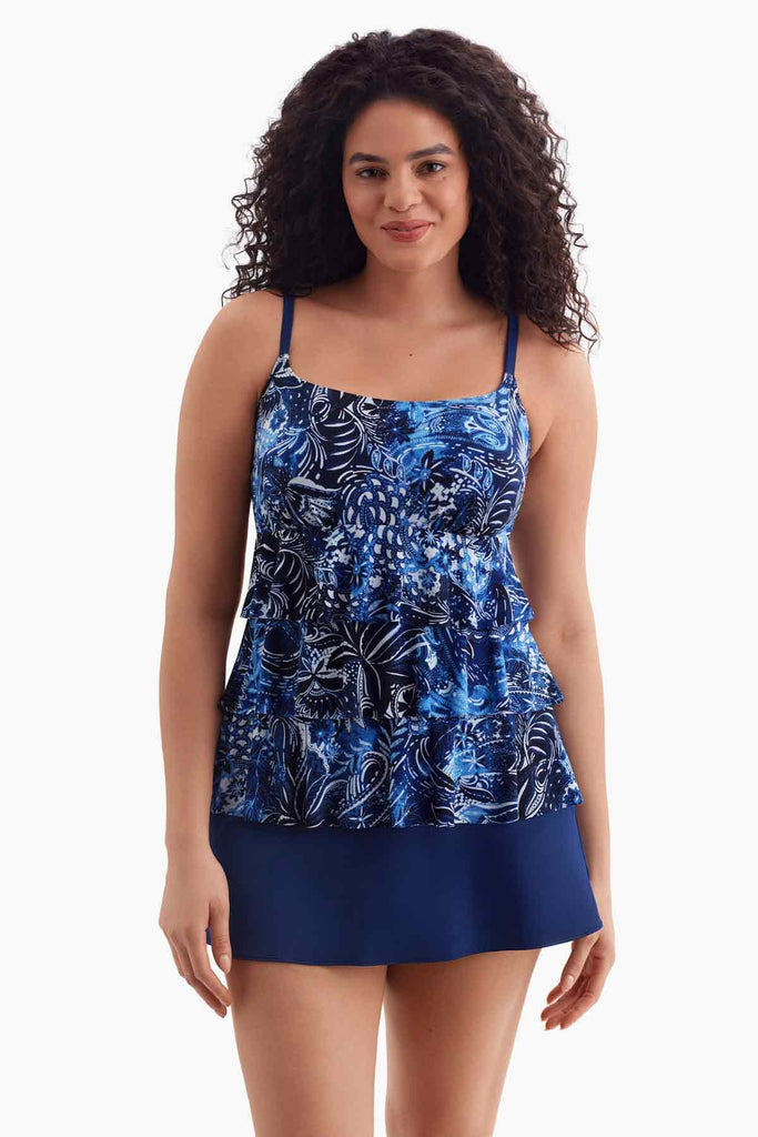 Woman wearing a tiered one-piece swimsuit with a blue abstract floral print