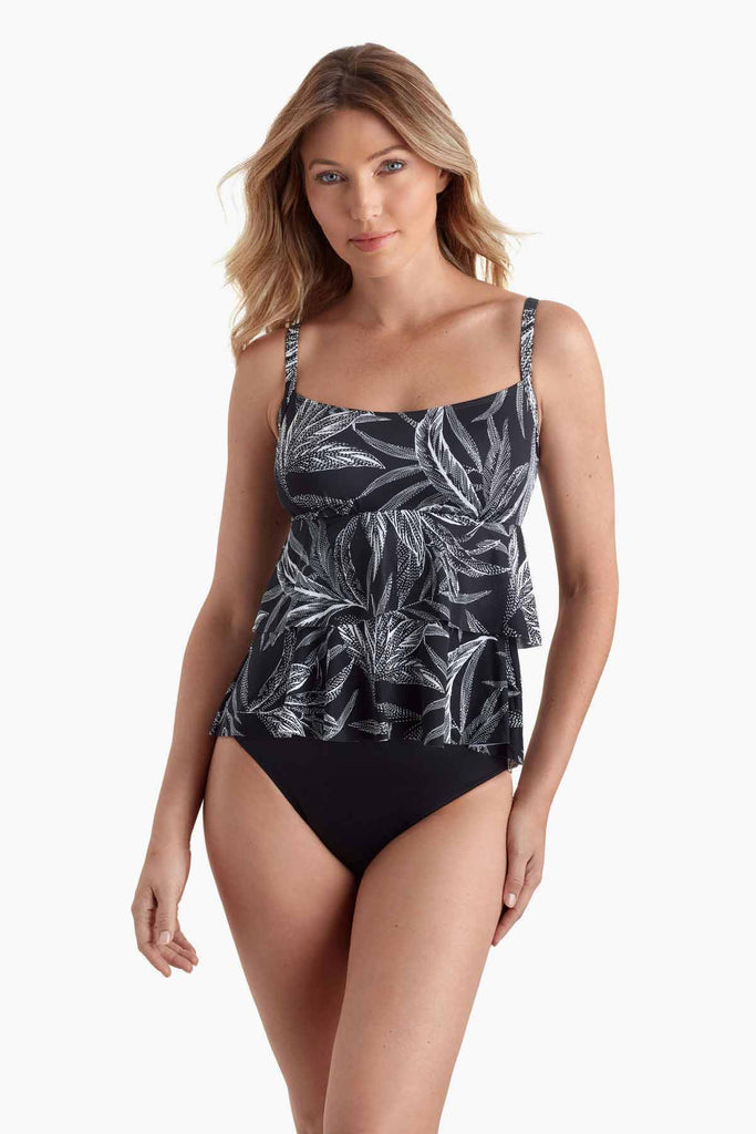 Woman wearing a tankini top with black and white palm leave print