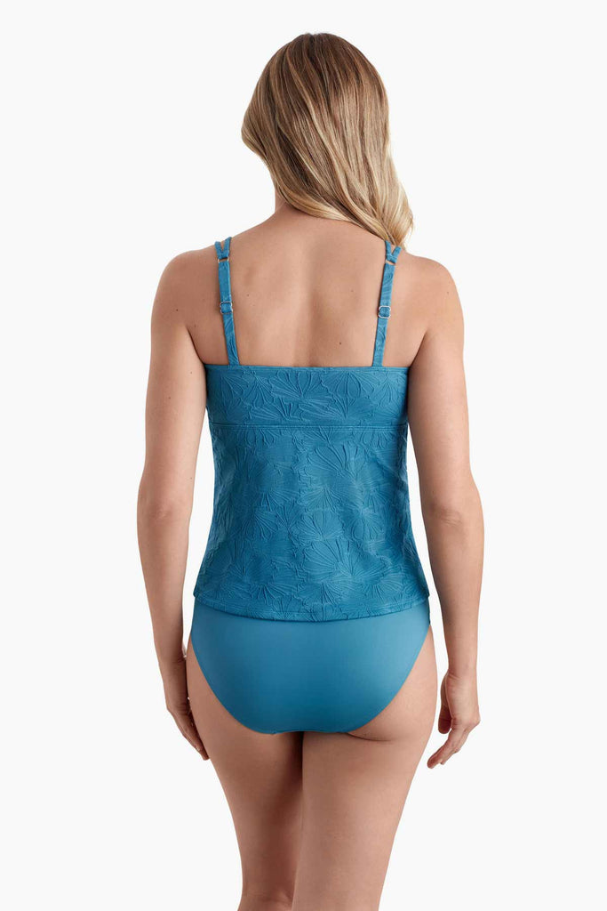 Woman faced away wearing a one-piece swimsuit with raised floral detail on the fabric