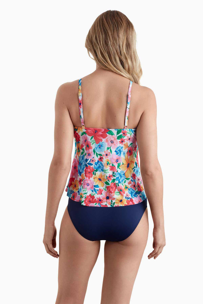 Woman turned away wearing a tankini top with multicolored floral print