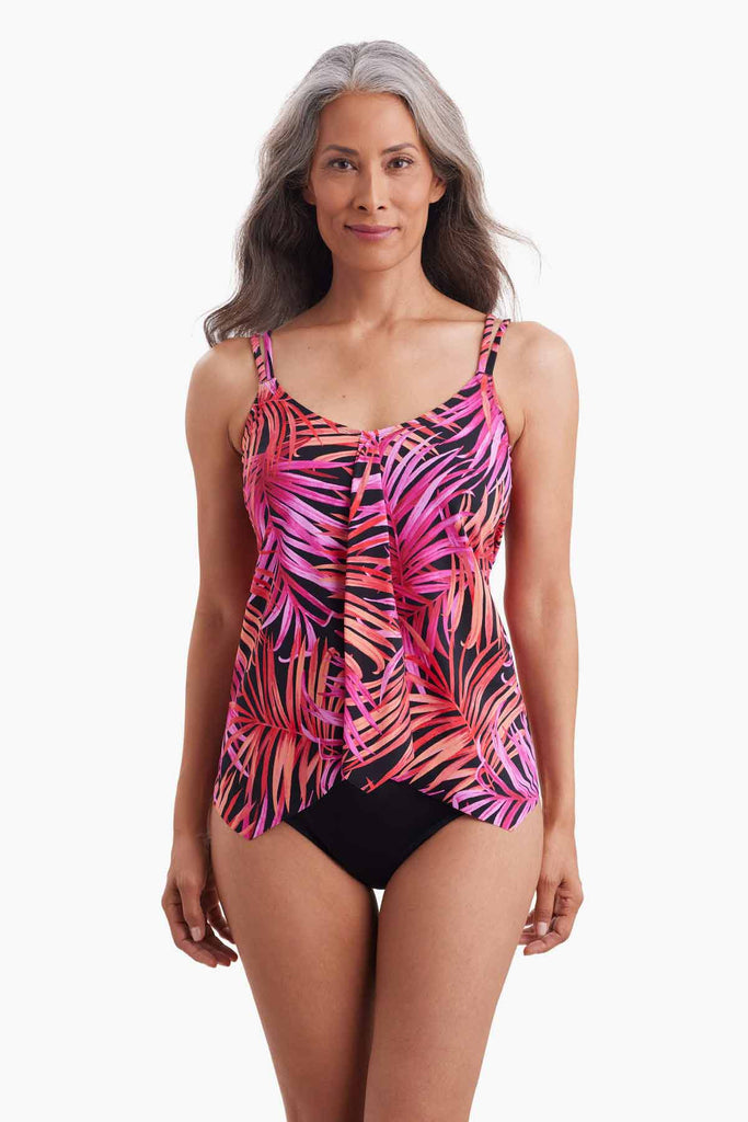 Woman wearing a handkerchief hem tankini top with pink palm leave print