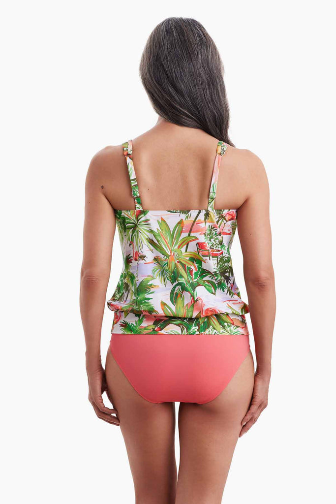 Woman faced away wearing a tankini top with a tropical flamingo print