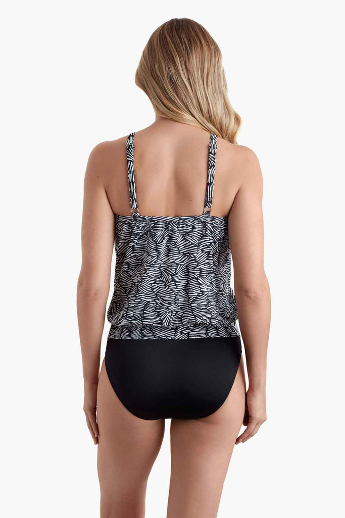 Woman turned away wearing a blouson style tankini top with a black and white pattern