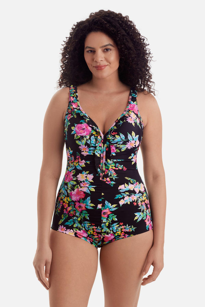 Woman wearing a multicolored floral printed one-piece swimsuit with ruffles on the neckline