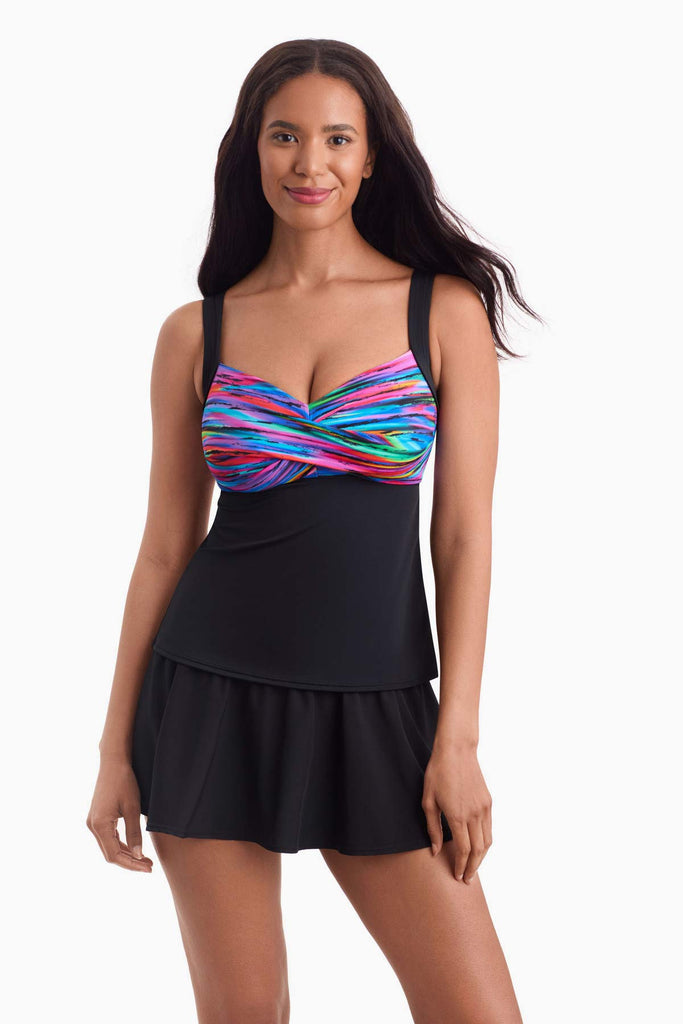 Woman wearing a tankini top with a multicolor print on the bust