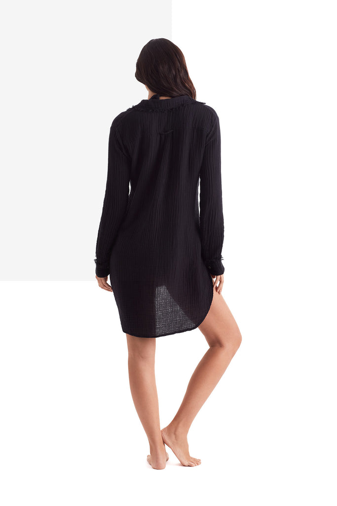 Woman faced away wearing a black long sleeve button up shirt 