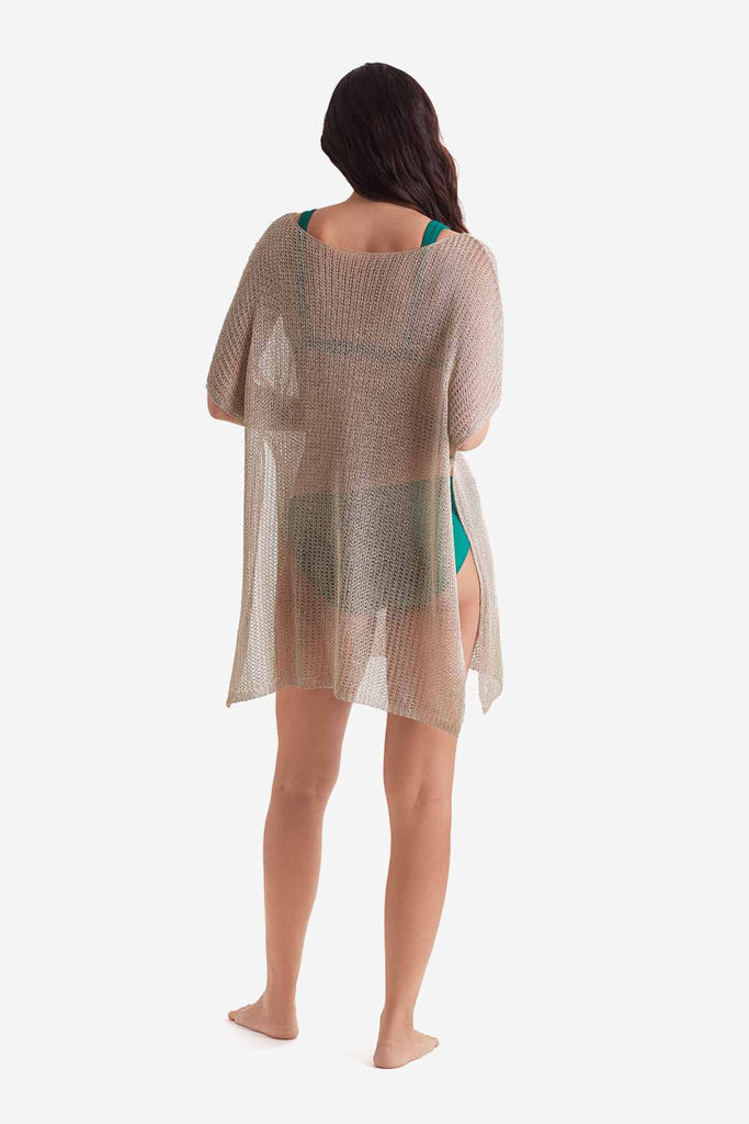 Woman faced away wearing a tunic swim dress cover up in metallic gold