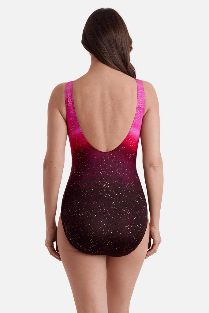 Woman turned away wearing a pink ombre one-piece swimsuit with shimmer detailing