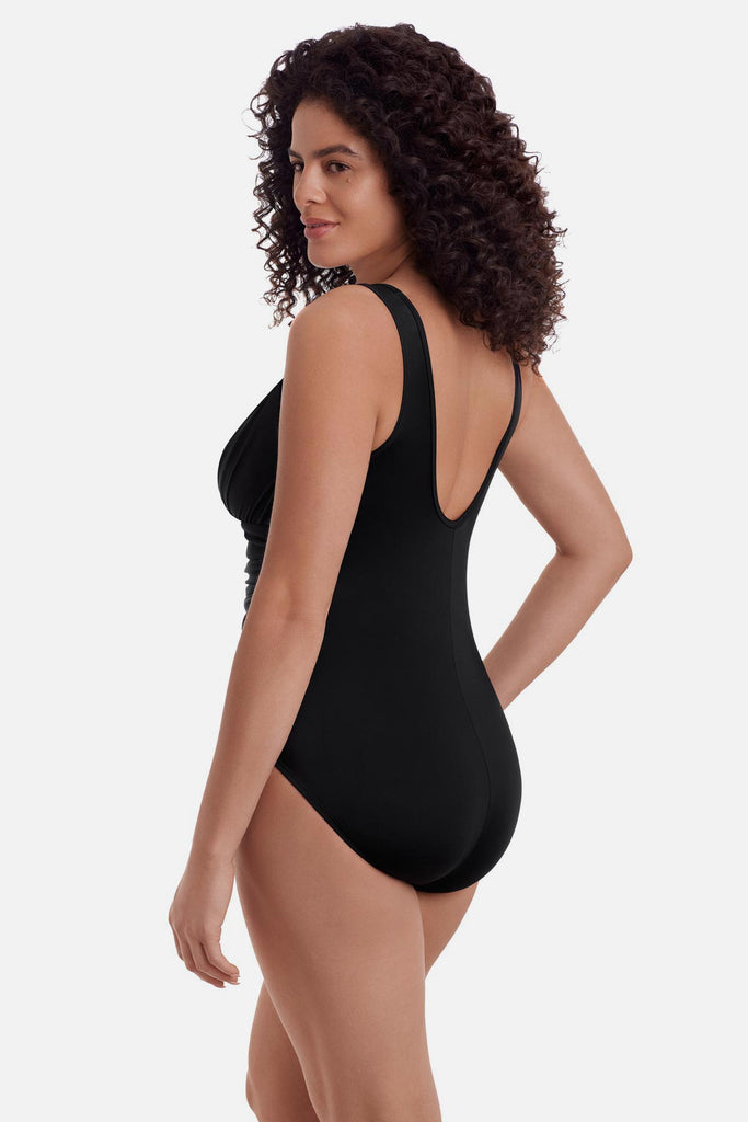 Woman turned left wearing a black one-piece swimsuit with a mesh high neck