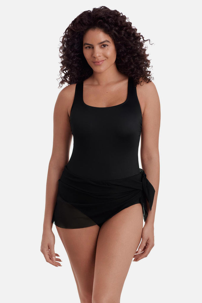 Woman wearing a black one-piece swimsuit with a black wrap sash around the waist