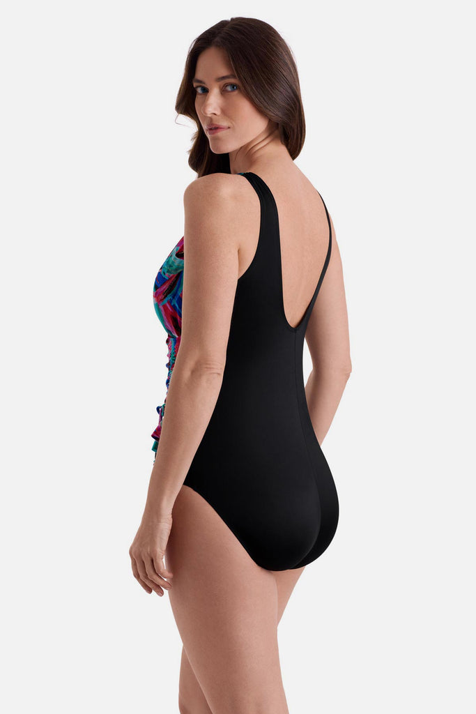 Woman turned left wearing a multicolored abstract printed one-piece swimsuit