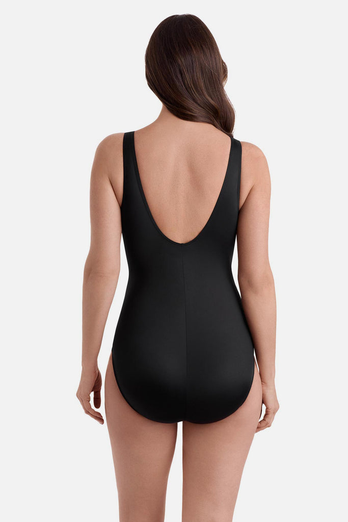 Woman wearing a black one-piece swimsuit with a scoop back