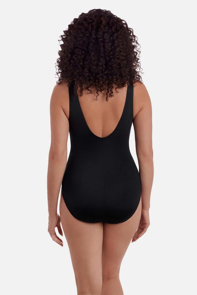 Woman turned away wearing a one-piece swimsuit with a scoop back