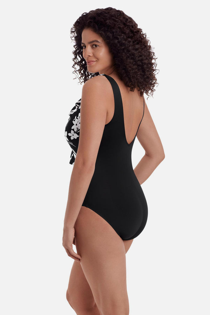 Woman turned left wearing a black and white floral one-piece swimsuit 