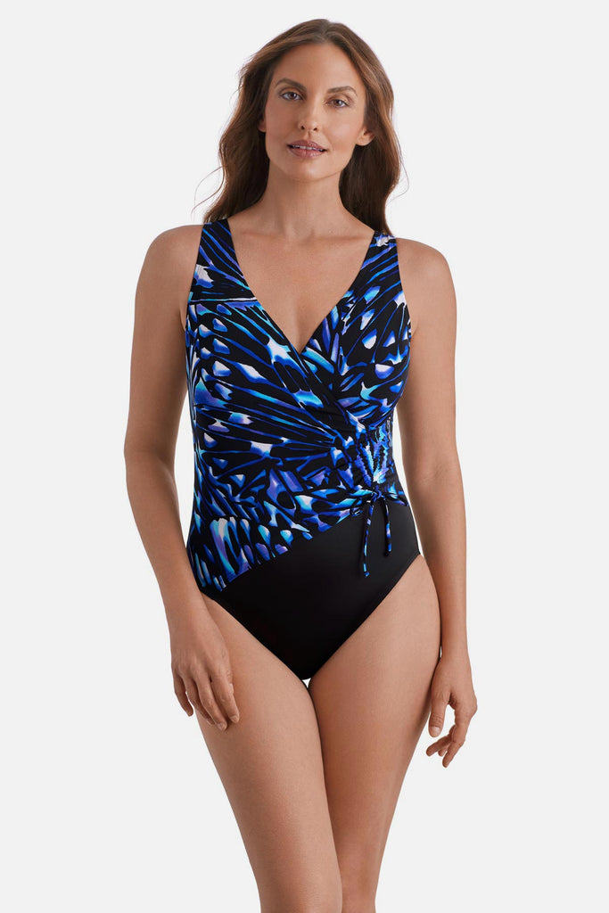 Woman wearing a blue abstract printed one-piece swimsuit with a side tie detail