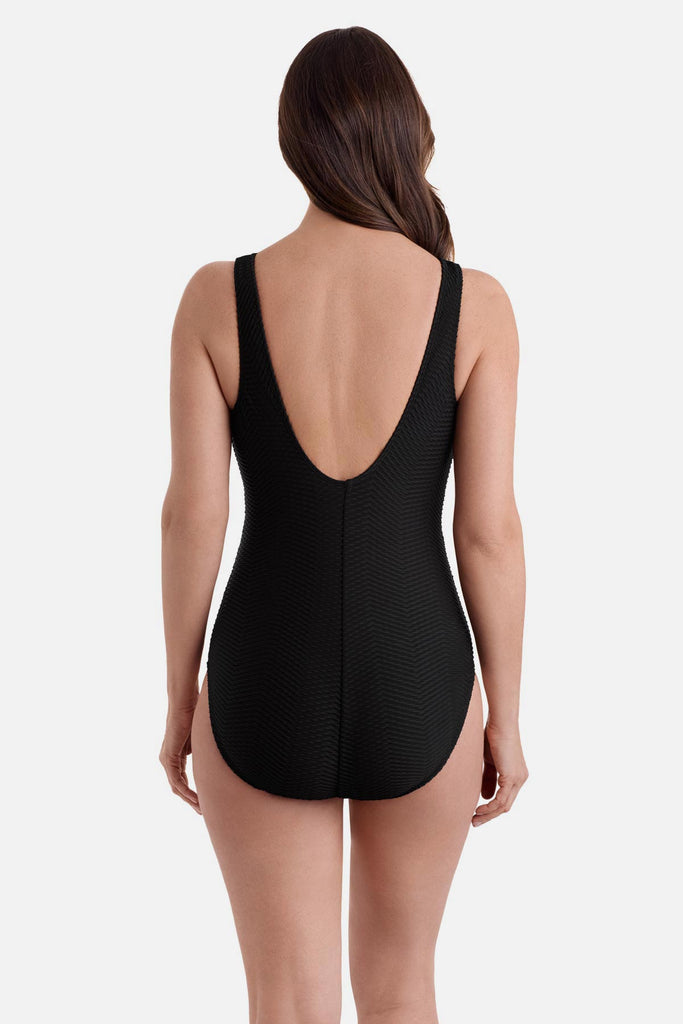 Woman wearing a black one-piece swimsuit with a scoop back