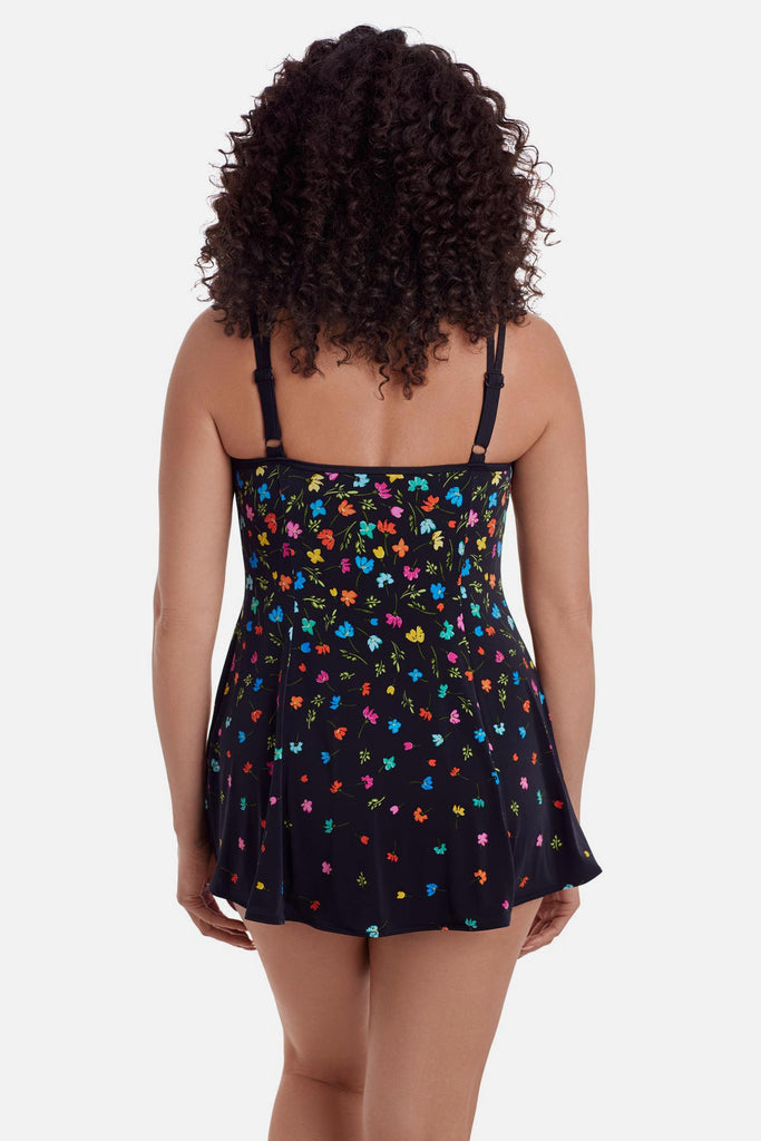 Woman faced away wearing a black swim dress with small multicolored flowers 