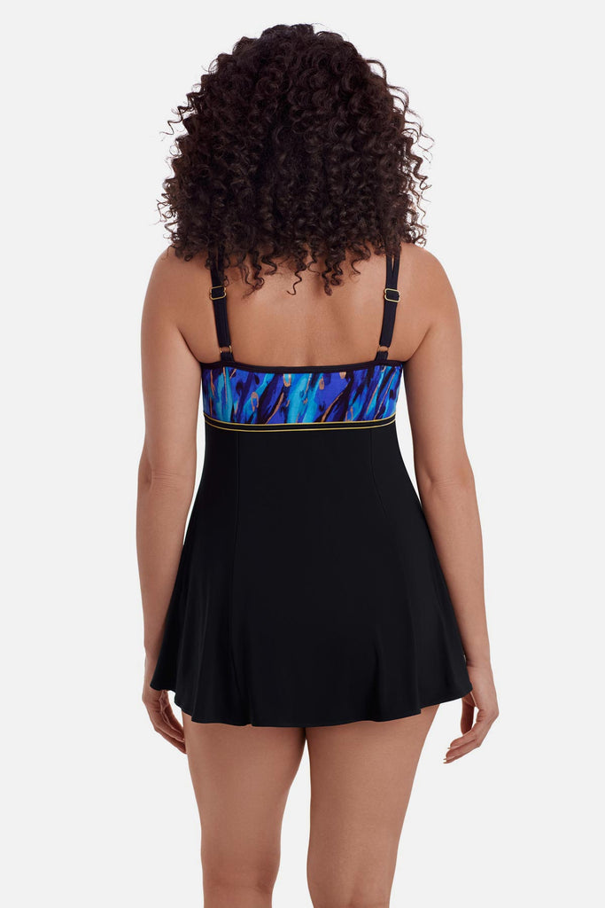 Woman turned away wearing a swim dress with a blue and gold print on the back