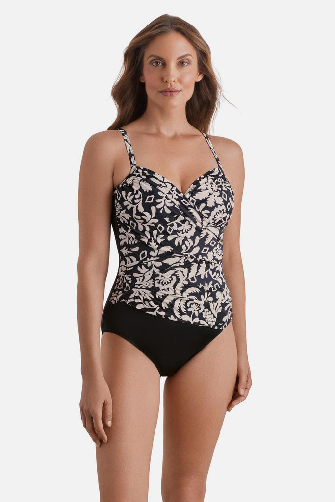 Woman wearing a black and white palm tree printed one-piece swimsuit