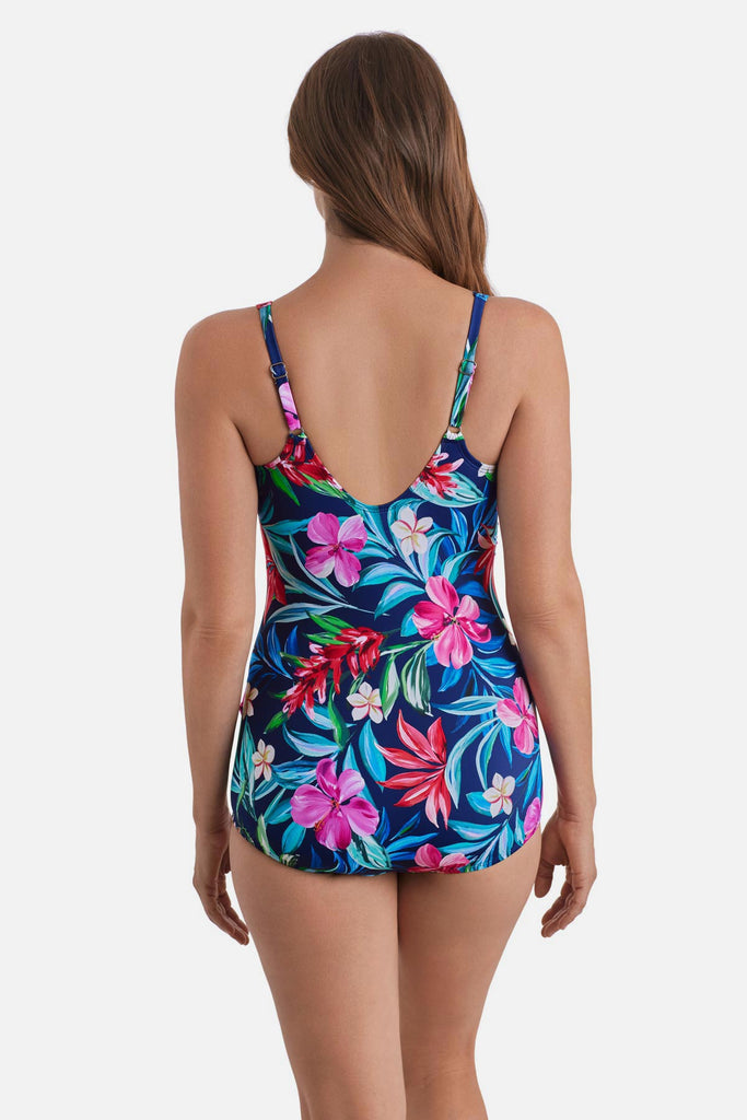Woman turned away wearing a multicolored floral and palm leaf printed sarong one-piece swimsuit