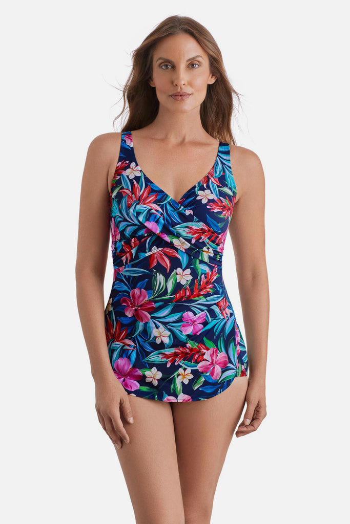 Woman wearing a multicolored floral and palm leaf printed sarong one-piece swimsuit