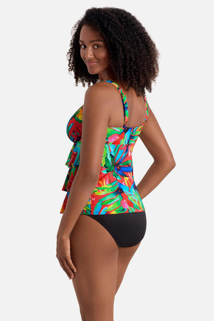 Woman turned left wearing a multicolored palm leaf printed tankini top with ruffles